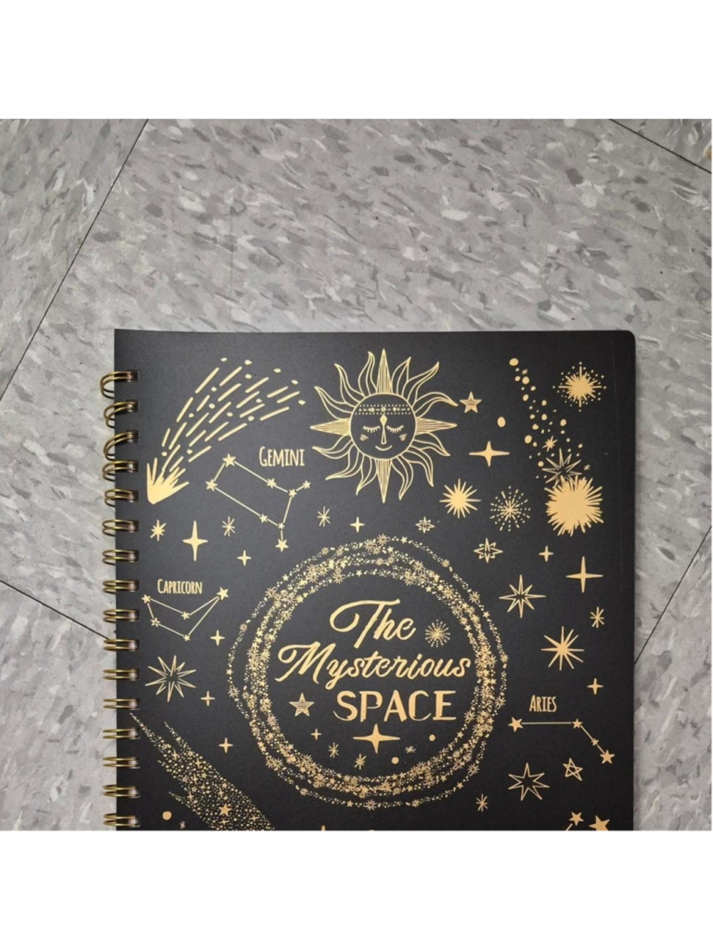 The Mysterious Space 2026 planner with gold zodiac constellations and stars on a